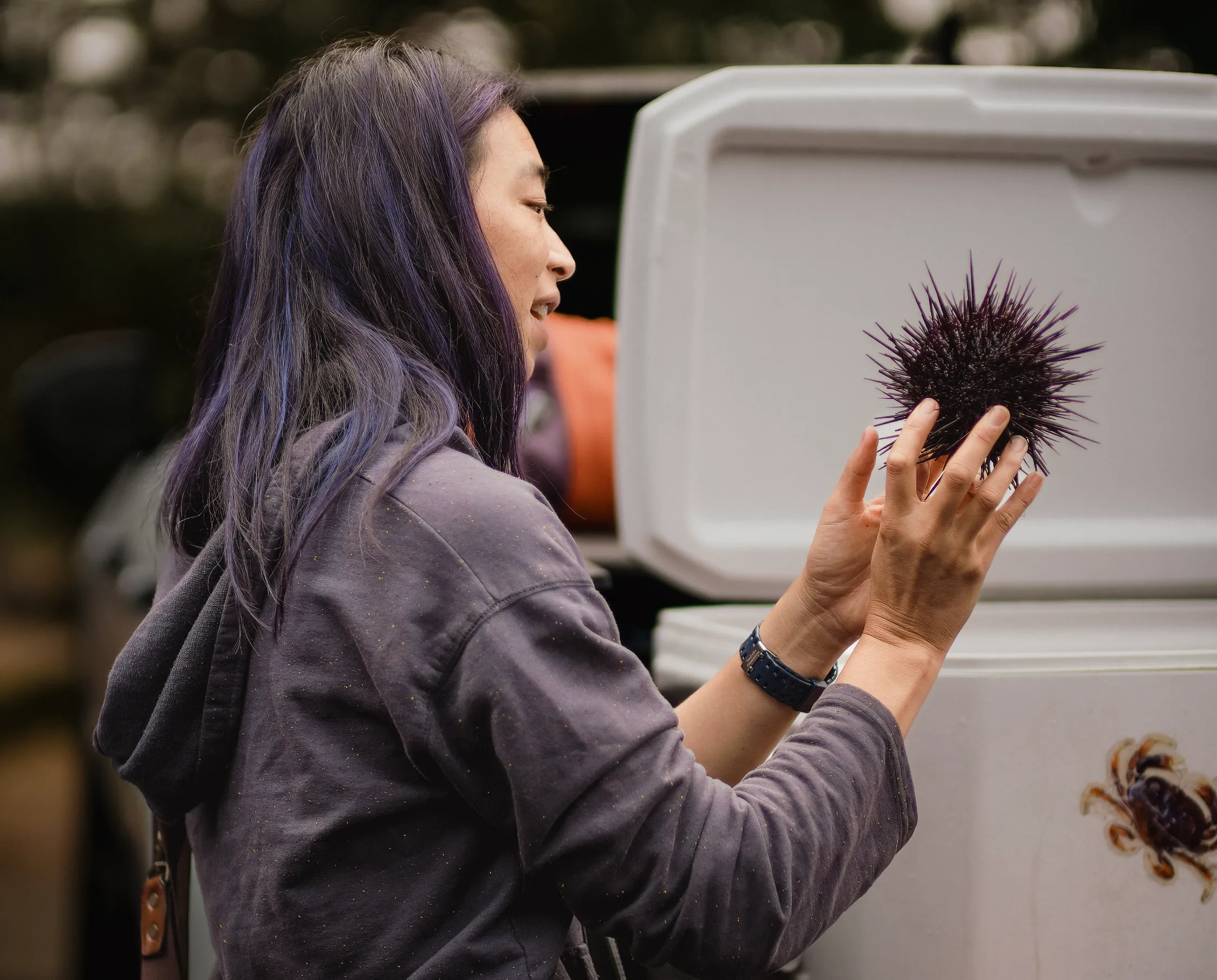 An attendee smiling while holding a purple sea urchin