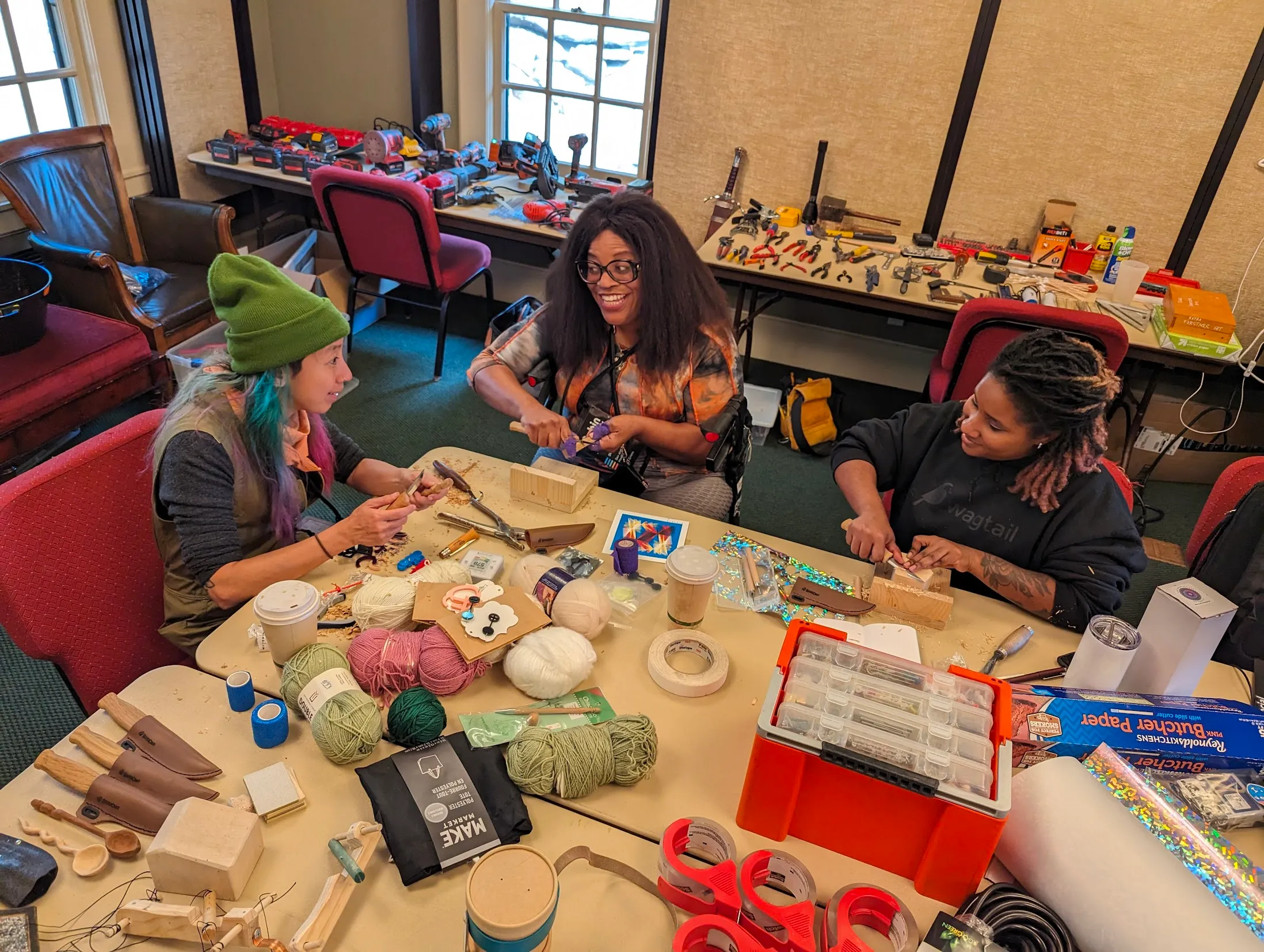 Attendees carving wood together at a workshop table